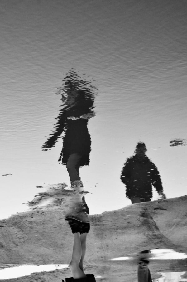 PHOTO SIREN, A WOMAN AND A MAN WALKING BEHIND HER NIKON D90 CAMERA, FOCAL 55mm, F 13 $ 500, ALICE POSLUSZNA